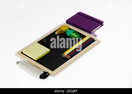 Notebook, black board, paper knife, highlighter, color pencil, correction pen, binder clip, sharpener, memory note isolated on white background Stock Photo