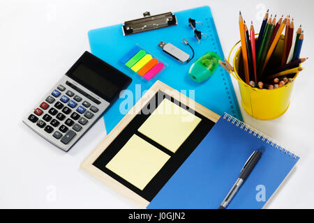 Plastic board, black board, calculator, notebook, flash drive, pen, pencil on yellow bucket isolated on white background Stock Photo