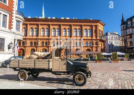 Old car in front of Art Museum Riga Bourse on Doms square. National architectural monument of Latvia, UNESCO world heritage site. Stock Photo