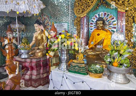 Buddha statue and donations, Popa Taung Kalat Temple, Mount Popa, near Bagan, Myanmar, (Burma) Stock Photo