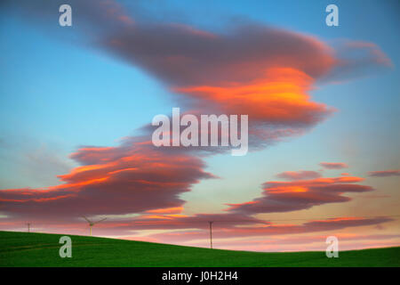 Lenticular 'UFO' Clouds form at dawn in Stonehaven, Scotland, UK UK Weather. 13th April, 2017.  Lenticular clouds are stationary lens-shaped clouds that form in the troposphere, normally in perpendicular alignment to the wind direction and have been regularly confused for UFOs throughout history due to the their smooth, round or oval structure. A distinctive cloud formation resembling lenses and are thought to be an explanation for some supposed UFO sightings. Stock Photo