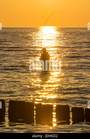 Ruegen, Germany. 9th Apr, 2017. A man fishes as the sun sets over the Baltic Sea in Dranske on the island of Ruegen, Germany, 9 April 2017. Photo: Patrick Pleul/dpa-Zentralbild/ZB/dpa/Alamy Live News Stock Photo