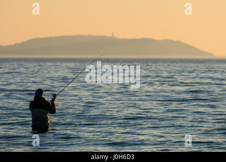 Ruegen, Germany. 9th Apr, 2017. A man fishes as the sun sets over the Baltic Sea in Dranske on the island of Ruegen, Germany, 9 April 2017. Photo: Patrick Pleul/dpa-Zentralbild/ZB/dpa/Alamy Live News Stock Photo