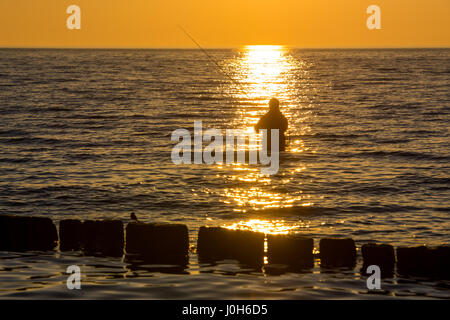 Ruegen, Germany. 9th Apr, 2017. A man fishes as the sun sets over the Baltic Sea in Dranske on the island of Ruegen, Germany, 9 April 2017. Photo: Patrick Pleul/dpa-Zentralbild/ZB/dpa/Alamy Live News Stock Photo