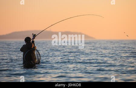 Ruegen, Germany. 9th Apr, 2017. A man fishes as the sun sets over the Baltic Sea in Dranske on the island of Ruegen, Germany, 9 April 2017. Photo: Patrick Pleul/dpa-Zentralbild/ZB/dpa/Alamy Live News Stock Photo