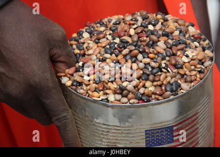 Ganyliel, South Sudan. 24th Mar, 2017. A woman holds up a tin containing beans and lentils distributed by the Welthungerhilfe (lit. World Hunger Aid) in Ganyliel, South Sudan, 24 March 2017. It is located in the South Sudanese state of Unity, the region most affected by famine in the country. Photo: Jürgen Bätz/dpa/Alamy Live News Stock Photo