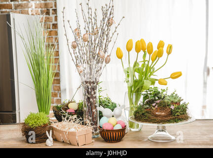 Beautiful Easter composition of catkins, colorful eggs and fresh flowers on table Stock Photo