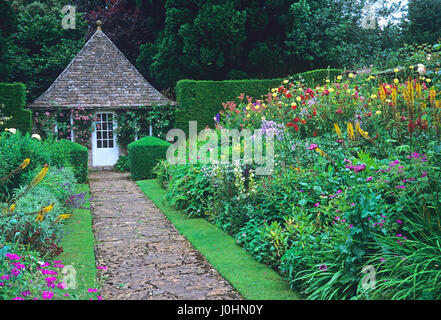 Path leading to garden room edged with colourful borders at Rodmarton Manor garden