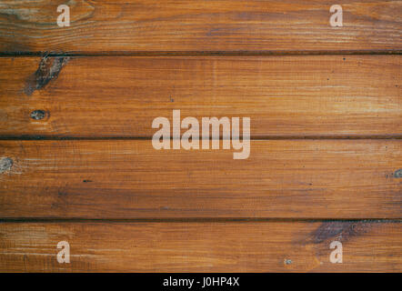 The old wooden surface is made of horizontal boards painted with red paint. Stock Photo