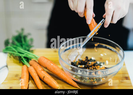 A Cook Grating Carrot to bake a Carrot Cake Stock Photo