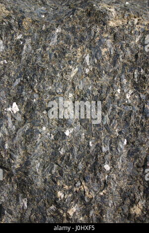 A dark grungy rock surface  as a background. Stock Photo