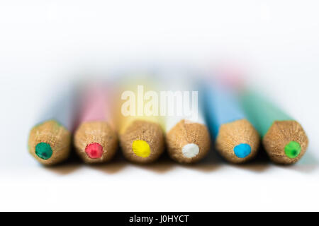 Row of colored crayons or pencils on white background, macro, closeup, defocused, abstract, styled photo for product marketing, social media, educatio Stock Photo