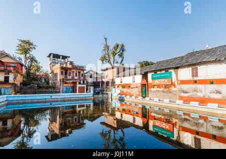 Dilapidated old buildings awaiting restoration reflected in the village tank (pond), Pragpur heritage village, Kagra district, Himachal Pradesh, India Stock Photo