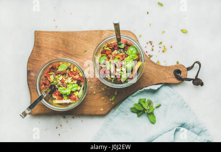 Healthy salad with quionoa, avocado, dried tomatoes in glass jars Stock Photo