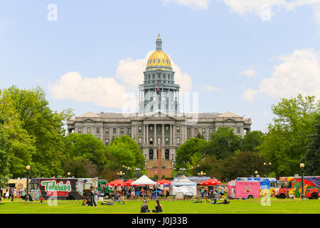 Denver, USA - May 25, 2016: The Colorado State Capitol seen from the Civic Center Park with food trucks in front and people sitting on the lawn. Stock Photo