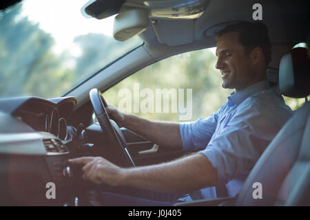 Side view of smiling man driving car Stock Photo