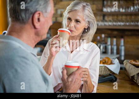 Senior couple interacting with each other while having coffee in cafÃƒÂ© Stock Photo