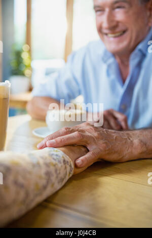 Senior couple holding hands while having coffee in cafÃƒÂ© Stock Photo