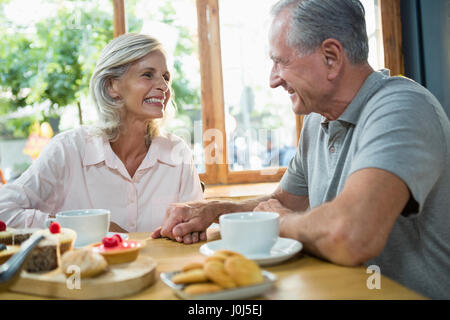 Senior couple interacting with each other in cafÃƒÂ© Stock Photo