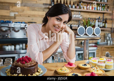 Portrait of waitress leaning at counter in cafÃƒÂ© Stock Photo
