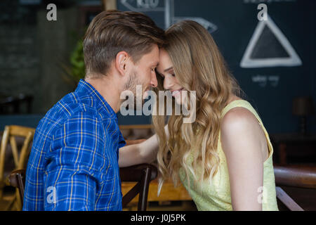 Close up of romantic couple with eyes closed standing in cafe shop Stock Photo