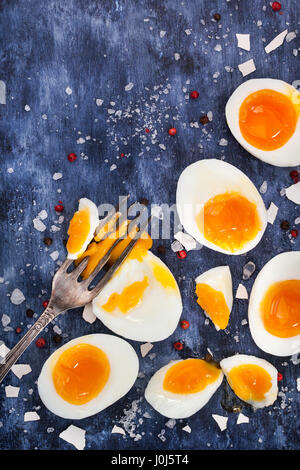 Hard boiled eggs, sliced in halves on wooden painted table Stock Photo