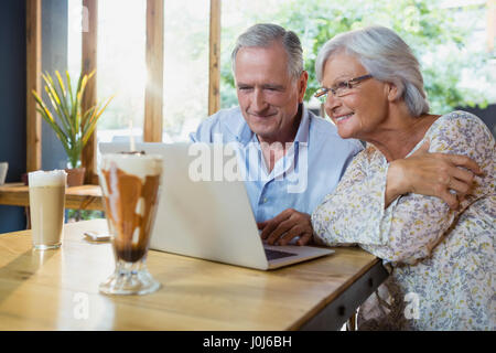 Senior couple using laptop in cafÃƒÂ© Stock Photo