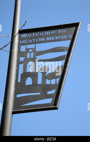 Iron work road sign on lamp post 'Welcome to Heaton Mersey' village between Didsbury and Stockport in Greater Manchester on Didsbury Road by cenotaph. Stock Photo