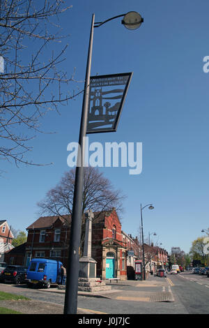 Iron work roadside sign 'Welcome to Heaton Mersey' village between Didsbury and Stockport in Greater Manchester on Didsbury Road by cenotaph by Church Stock Photo