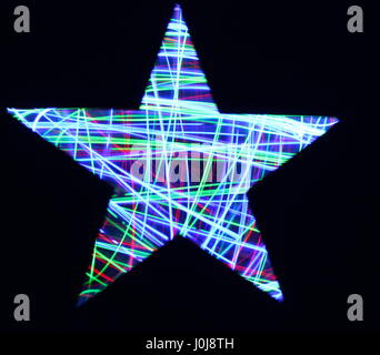 Multi-coloured light painting photography, fairy lights behind a cut-out star stencil Stock Photo