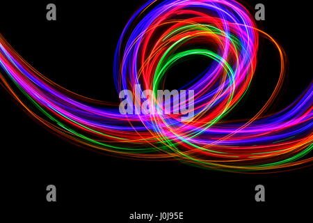 Multi-coloured light painting photography - movement and motion on a black background. Long exposure photograph of neon colour in an abstract pattern Stock Photo