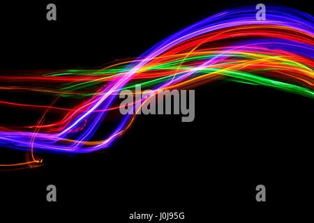 Multi-coloured light painting photography - movement and motion on a black background. Long exposure photograph of neon colour in an abstract pattern Stock Photo