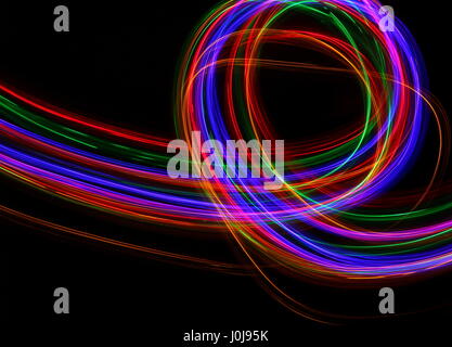 Multi-coloured light painting photography - movement and motion on a black background. Long exposure photograph of neon colour in an abstract pattern Stock Photo