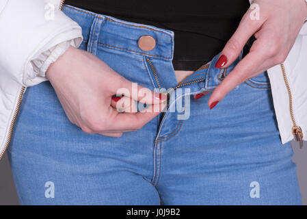 Woman zipping her blue jeans zip Stock Photo - Alamy