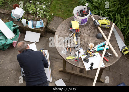 An overview of a handyman engaged in some DIY work on the garden patio Stock Photo
