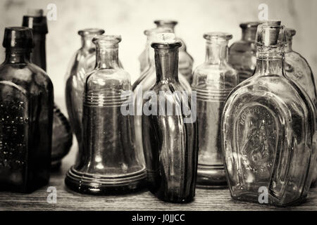 Selection of coloured glass bottles on a rustic background Stock Photo