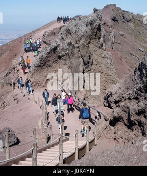 Tourists walk by the rim of the crater of Mount Vesuvius in Campania, Italy Stock Photo