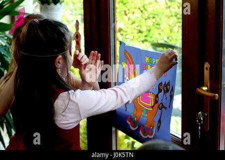 Children blind folded playing pin the tail on the Donkey at a birthday party games concept, childhood fun, joy, blindfolded, kids playing, family Stock Photo