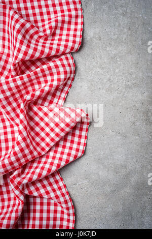 Red folded tablecloth on gray stone table. Top view Stock Photo