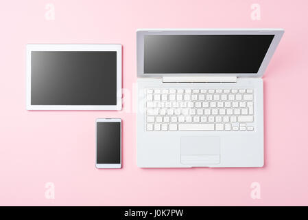 Technology background with modern white computer, tablet and smart phone on pink background Stock Photo