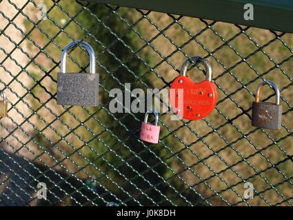A lot of closed padlock in a pederestrian bridge in Zamosc. Padlock were locked for lovers as sign their love. Bridge in Zamosc, Poland Stock Photo