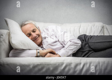 Old man sleeping on couch Stock Photo