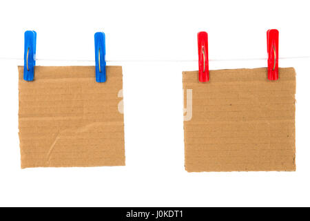 Blank cardboard on the rope is attached using red and blue clothespin isolated on white background Stock Photo