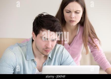 Young couple having problems using laptop, looking frustrated an Stock Photo