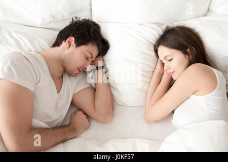 Happy young couple sleeping together in bed, enjoying sweet drea Stock Photo