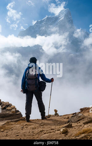 A trekker enjoys the view of Taboche Peak, near Pheriche, Nepal Himalaya. Photo © robertvansluis.com Stock Photo
