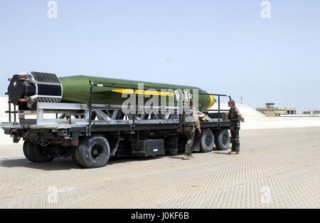 A U.S. Air Force Massive Ordnance Air Blast (MOAB) bomb sits on the flight line on a flatbed trailer for possible use during Operation Iraqi Freedom May 3, 2003 in Al Udeid Air Base, Qatar.  The MOAB is a precision-guided munition weighing 21,500 pounds and is the largest non-nuclear conventional weapon in existence. Stock Photo