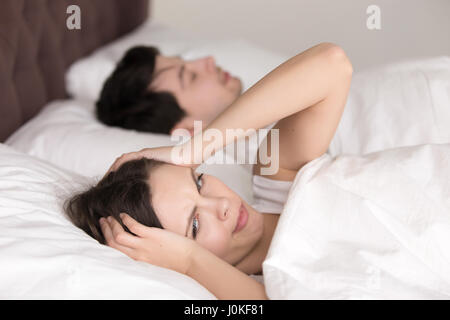 Couple in bed, woman suffering from insomnia, headache, snoring  Stock Photo