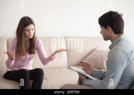 Conversation between male psychologist and young female patient, Stock Photo