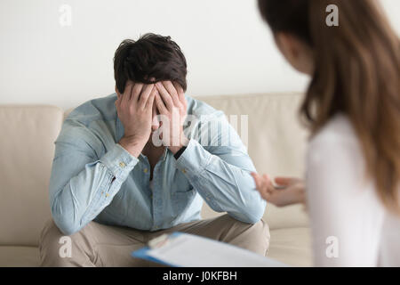 Upset male patient feeling depressed, receiving bad news from do Stock Photo